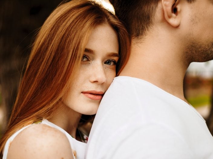 ragazza con i capelli rossi abbraccia un uomo