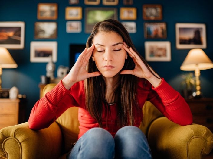 pensare troppo, ragazza che pensa sulla poltrona di casa, overthinking