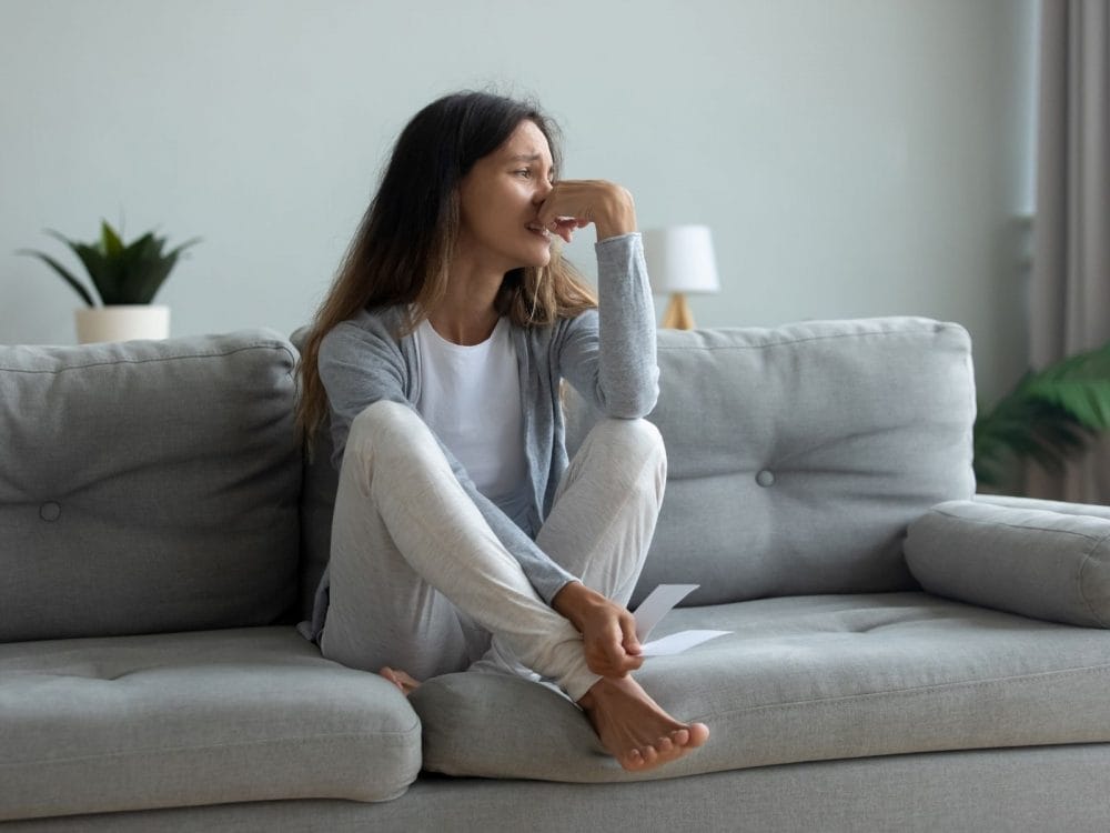 donna che piange sul divano, reattività emotiva