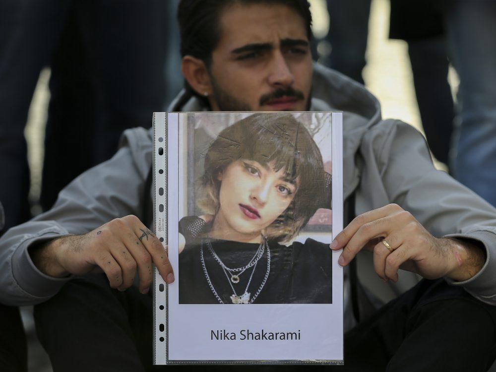 Un uomo mostra la fotografia Nika Shakarami durante una manifestazione di solidarietà a Napoli